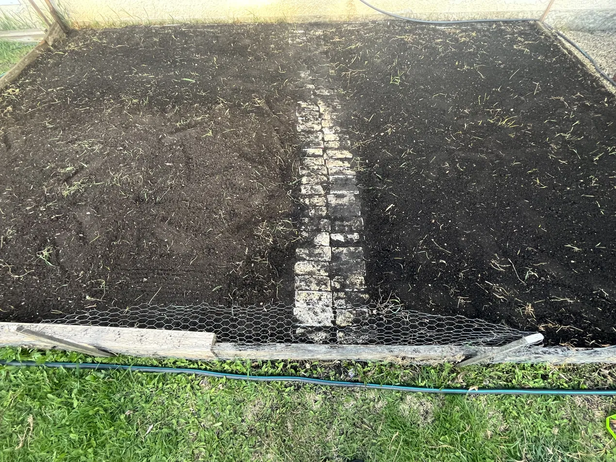 The first Viridian Botanicals garden bed, freshly tilled with a stone path running down the center.